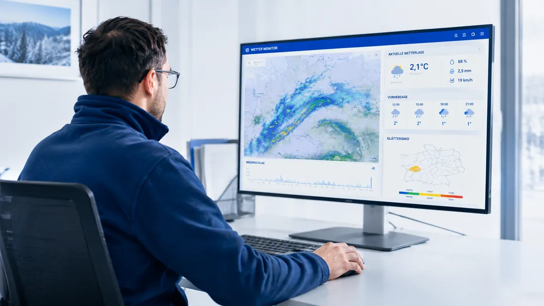 Mitarbeiter beobachtet die Wetterlage an einem Monitor mit Niederschlagsradar